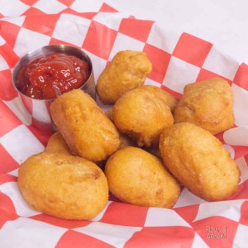 Air Fryer mini corn dogs in basket with small container of ketchup.
