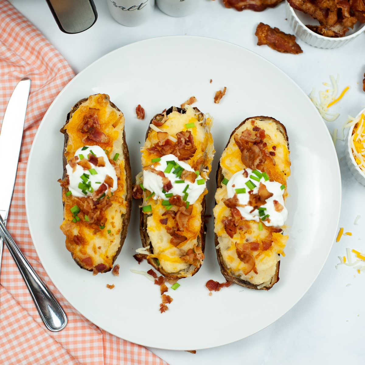 Top down view of three twice baked potatoes on a plate.