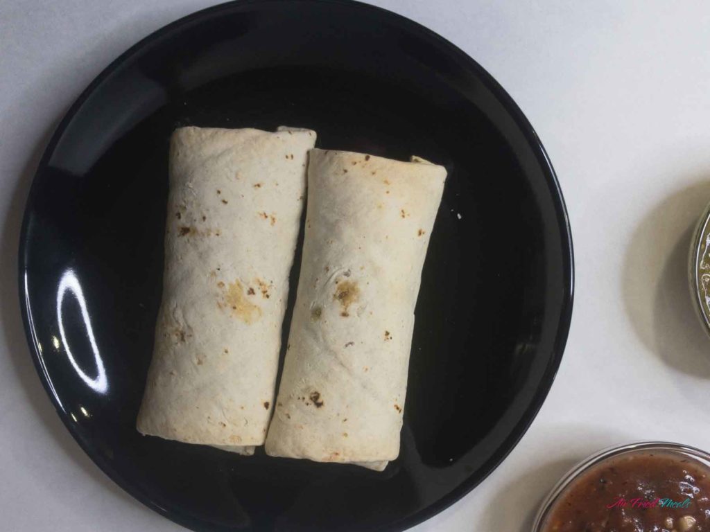 Two burritos on a plate.