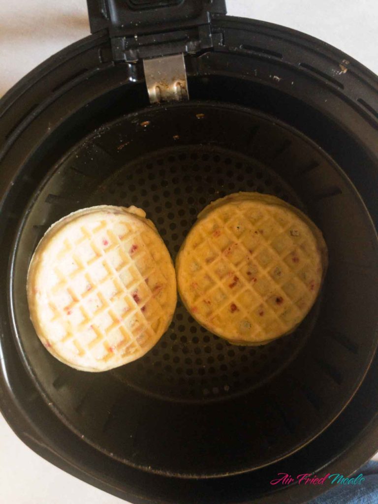frozen waffles in air fryer basket.