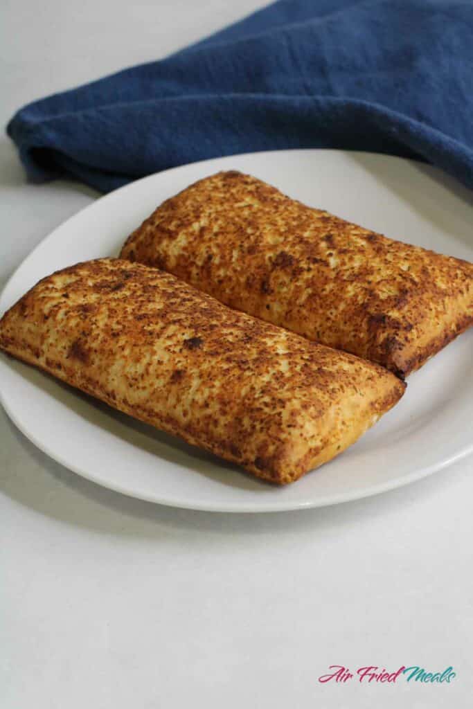 2 cooked hot pockets on a plate.