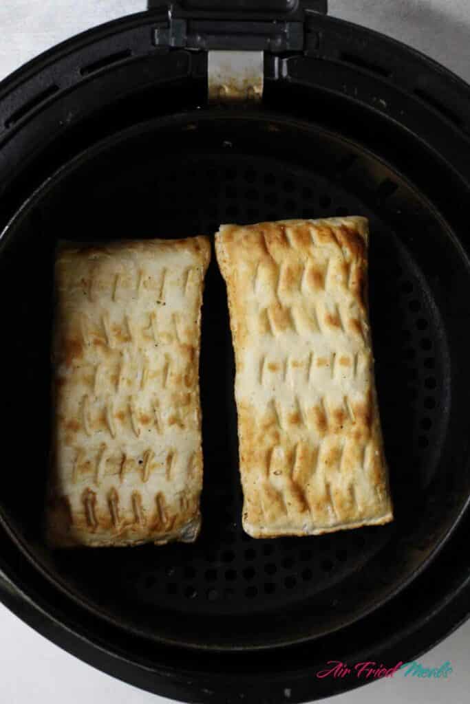 Uncooked hot pocket in air fryer basket.