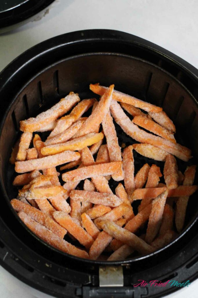 frozen sweet potato fries in air fryer basket.